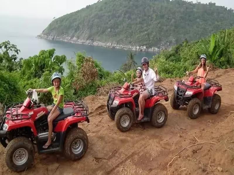 Group of tourists riding ATV quad bikes on a jungle trail in Phuket, Thailand