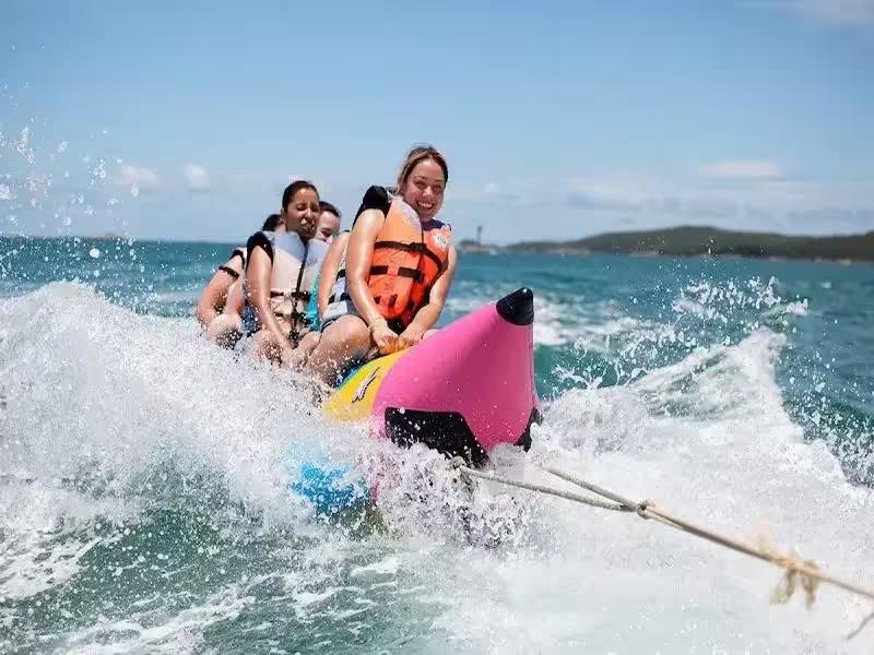 Group of friends on a fun banana boat ride at Coral Island Phuket