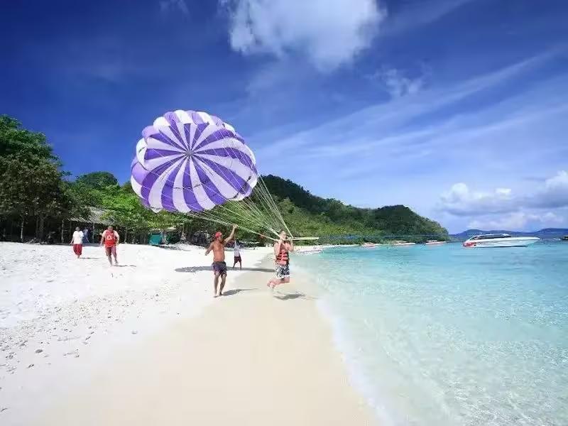 Guests enjoying parasailing at Coral Island (Koh Hae) on a day trip from Phuket