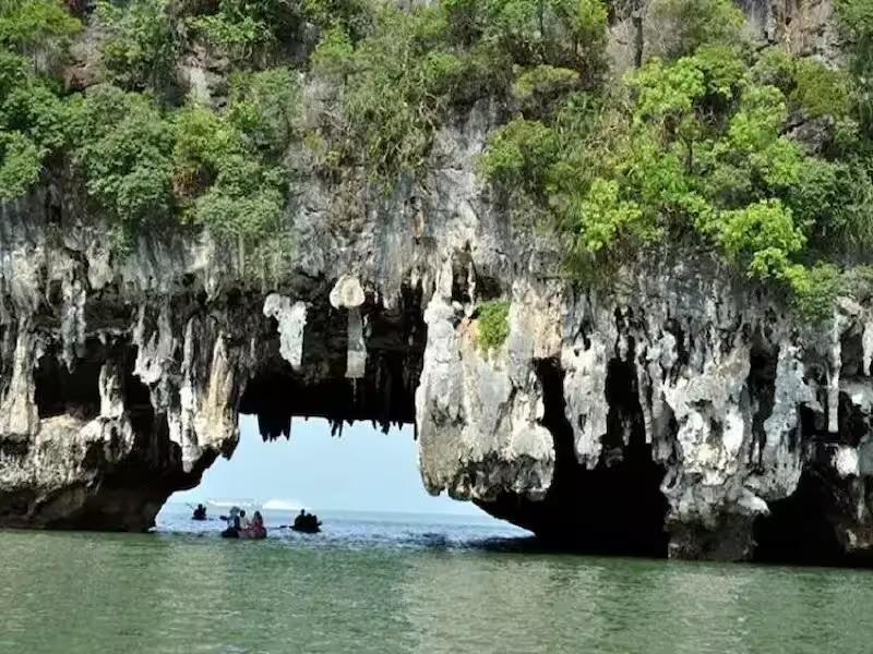Canoeing through the narrow tidal cave at Talu Island, Phang Nga Bay.