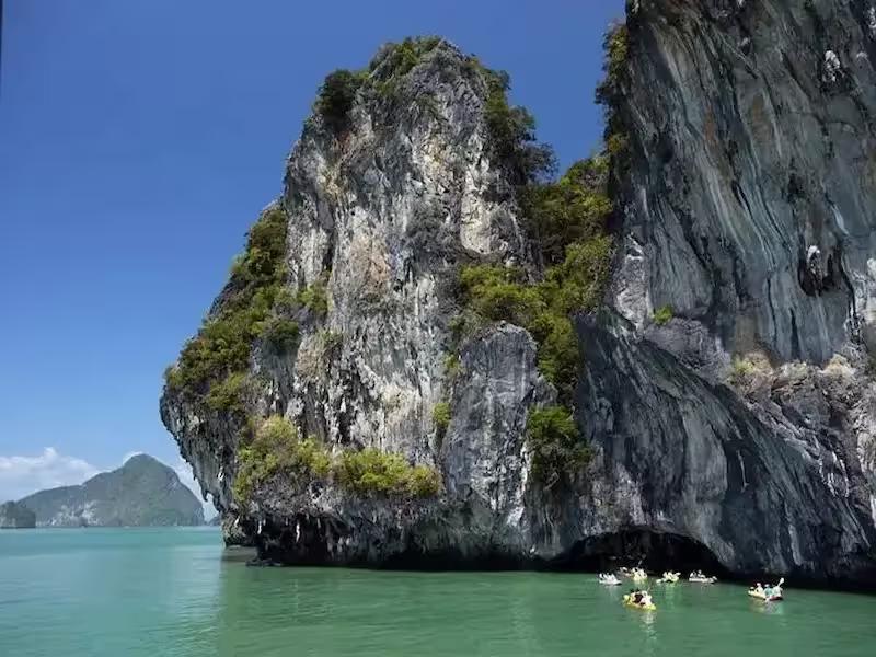 A longtail boat navigates the mangrove forests and caves around Panak Island in Phang Nga Bay