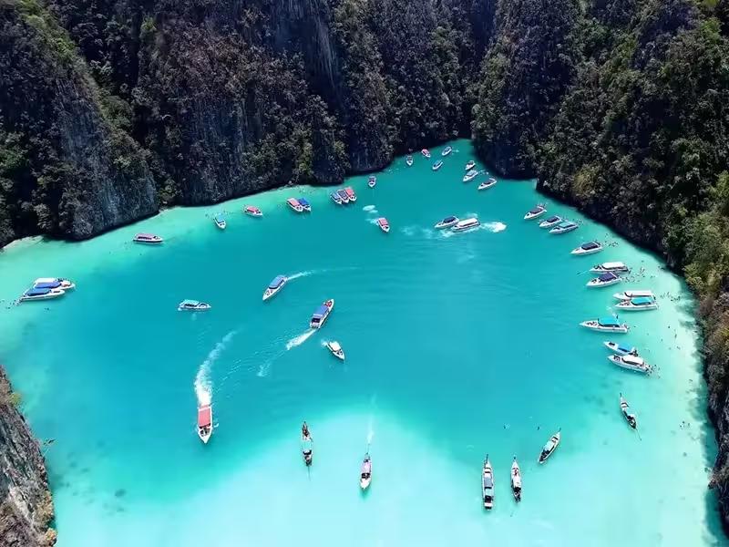 Aerial view of Pileh Cove's emerald green lagoon surrounded by limestone cliffs in Phi Phi Islands, Thailand