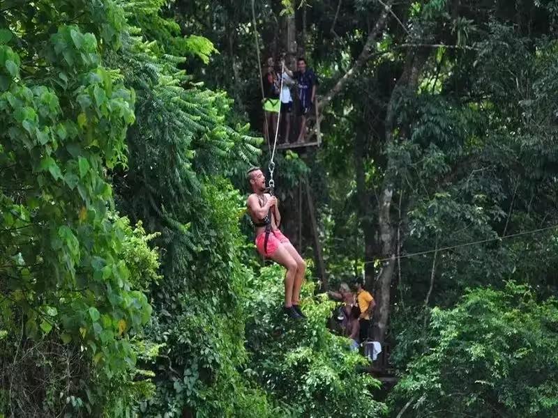 Person ziplining (Flying Fox) over the jungle on an adventure tour